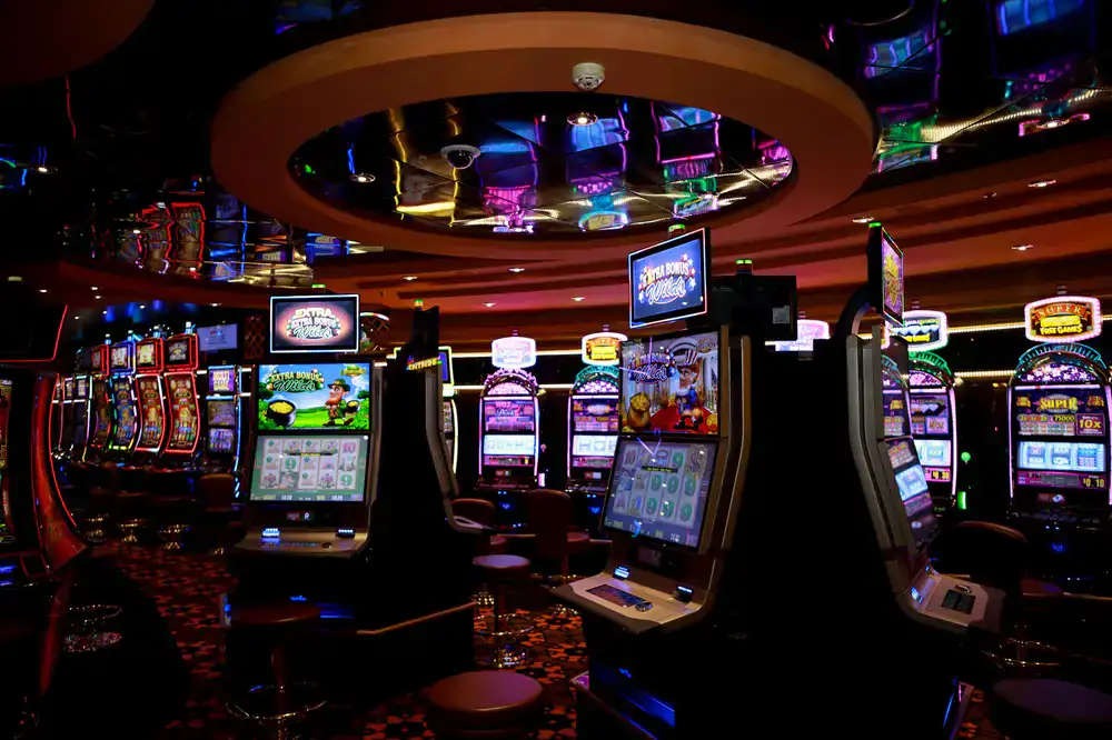 A wide view of the bustling arcade floor with players intensely focused on music games