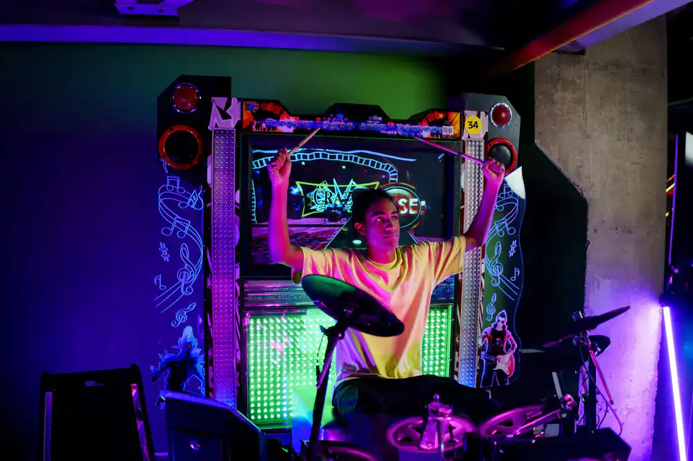 A player rapidly hitting pads on a digital drum arcade machine